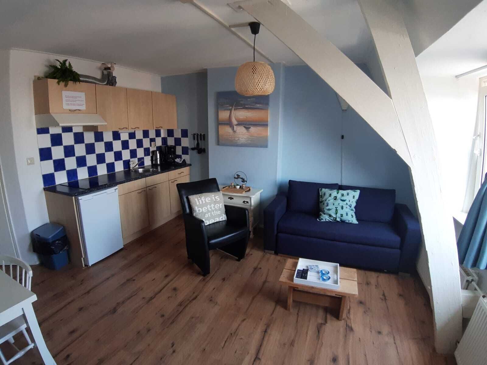 Een knus woongedeelte met een keuken, een eethoek en een zithoek.