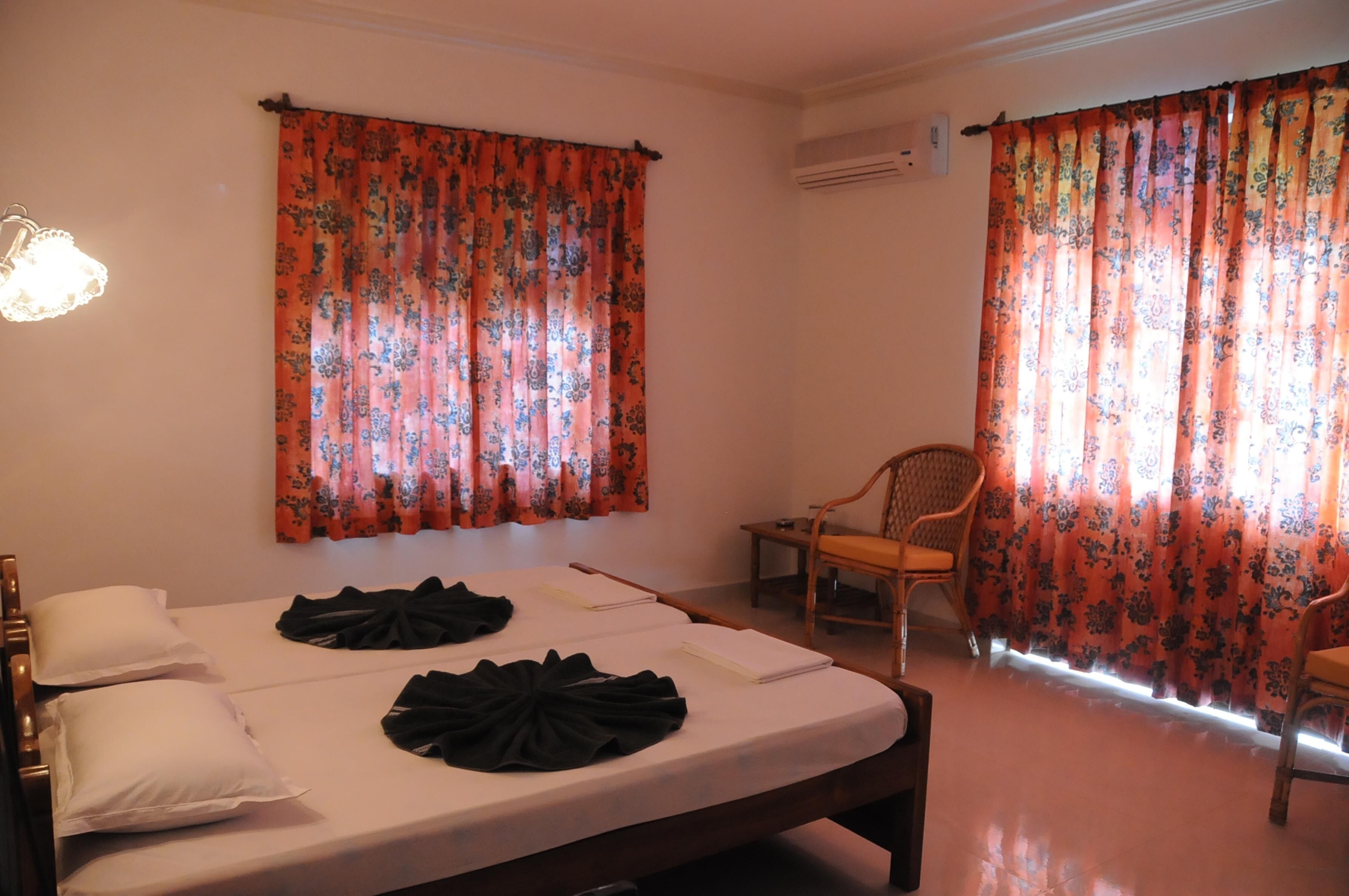 Una habitación con una cama, dos sillas y una mesita.