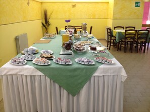 A buffet table with various food items and a coffee station.