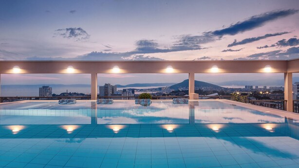 A rooftop infinity pool with a cityscape view, including a mountain and buildings. - Dioklecijan Hotel & Residence (Split)