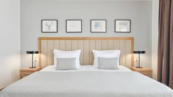 Habitación de hotel con una cama grande, dos mesitas de noche y cuatro obras de arte enmarcadas en la pared.