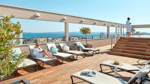 A rooftop terrace with lounge chairs, a staircase, and a view of the sea. - Dioklecijan Hotel & Residence (Split)