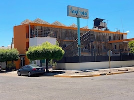 Un edificio con un letrero que dice 'MaxiHotel' y una escalera que lleva a un nivel superior.