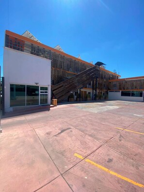 A building with a modern architectural design, featuring a prominent staircase and a flat-roofed structure with large windows. - Maxihotel Los Mochis (Los Mochis)