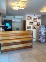 Un mostrador de recepción de diseño moderno, un televisor montado y fotografías enmarcadas en la pared.