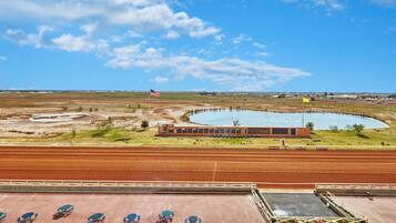 A racetrack with a building, a flag, and a water feature.