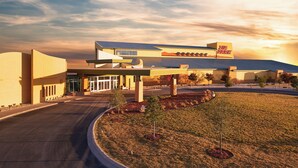A commercial building with a large parking lot, a covered entrance, and a sign that reads "Ria Park". - Zia Park Hotel (Hobbs)