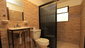 Un baño con inodoro, lavabo y espejo.