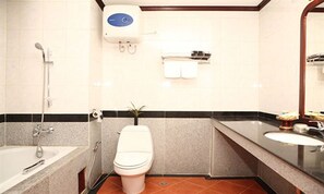 A bathroom with a bathtub, toilet, sink, and a mirror. - Vansana Riverside Hotel (Vientiane)