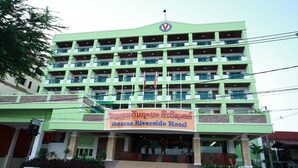 A multi-story hotel with a green facade and a sign in a local language. - Vansana Riverside Hotel (Vientiane)