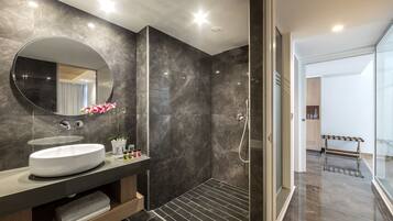 Een moderne badkamer met een grote ronde spiegel, een wit wastafelmeubel en een douche.