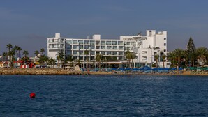 A modern hotel with multiple floors, balconies, and a beachside location. - Limanaki Beach Hotel (Ayia Napa)