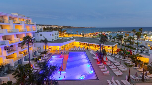 A hotel with a rooftop pool, multiple balconies, and a view of the sea. - Limanaki Beach Hotel (Ayia Napa)