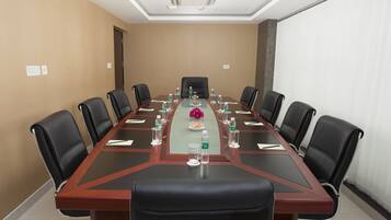 A conference room with a long table, black leather chairs, and water bottles.