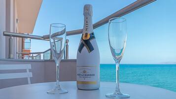 Una botella de Moët & Chandon Ice Imperial champagne sobre una mesa, con dos copas, con vista al mar.