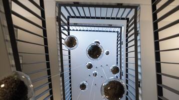 A modern interior with a geometric metal railing and spherical glass terrariums.