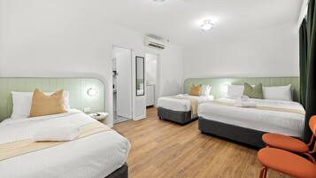 Habitación Deluxe, varias camas | Escritorio, wifi gratis y ropa de cama