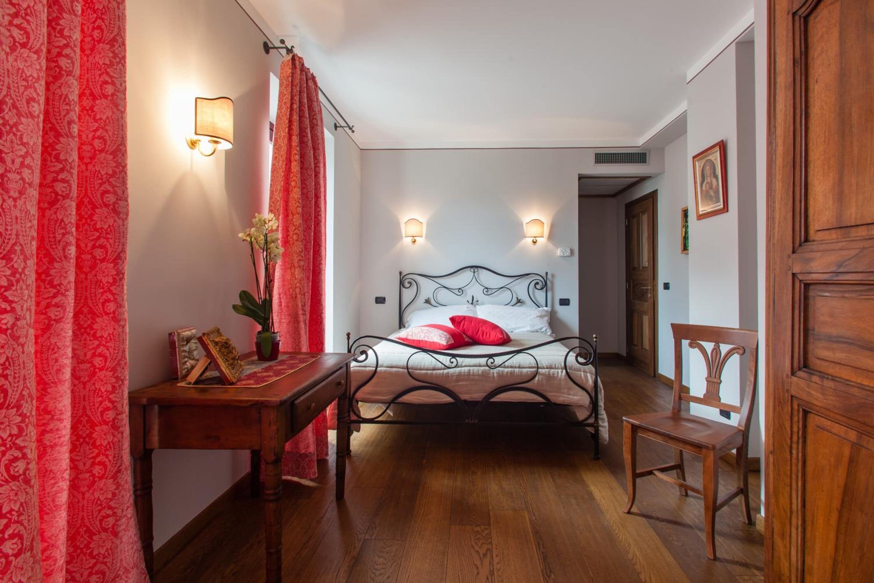 Une chambre à coucher avec un lit, une table de chevet, une chaise et un bureau.
