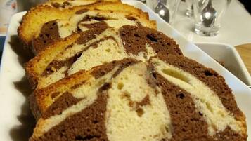 A loaf of marble cake with a white and brown swirl pattern, placed on a white plate.