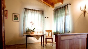 Una habitación con una mesa de madera, una silla y una planta en maceta.