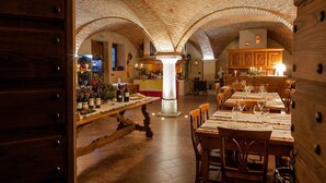 Un restaurante con un interior rústico, que presenta arcos de ladrillo visto y mobiliario de madera.
