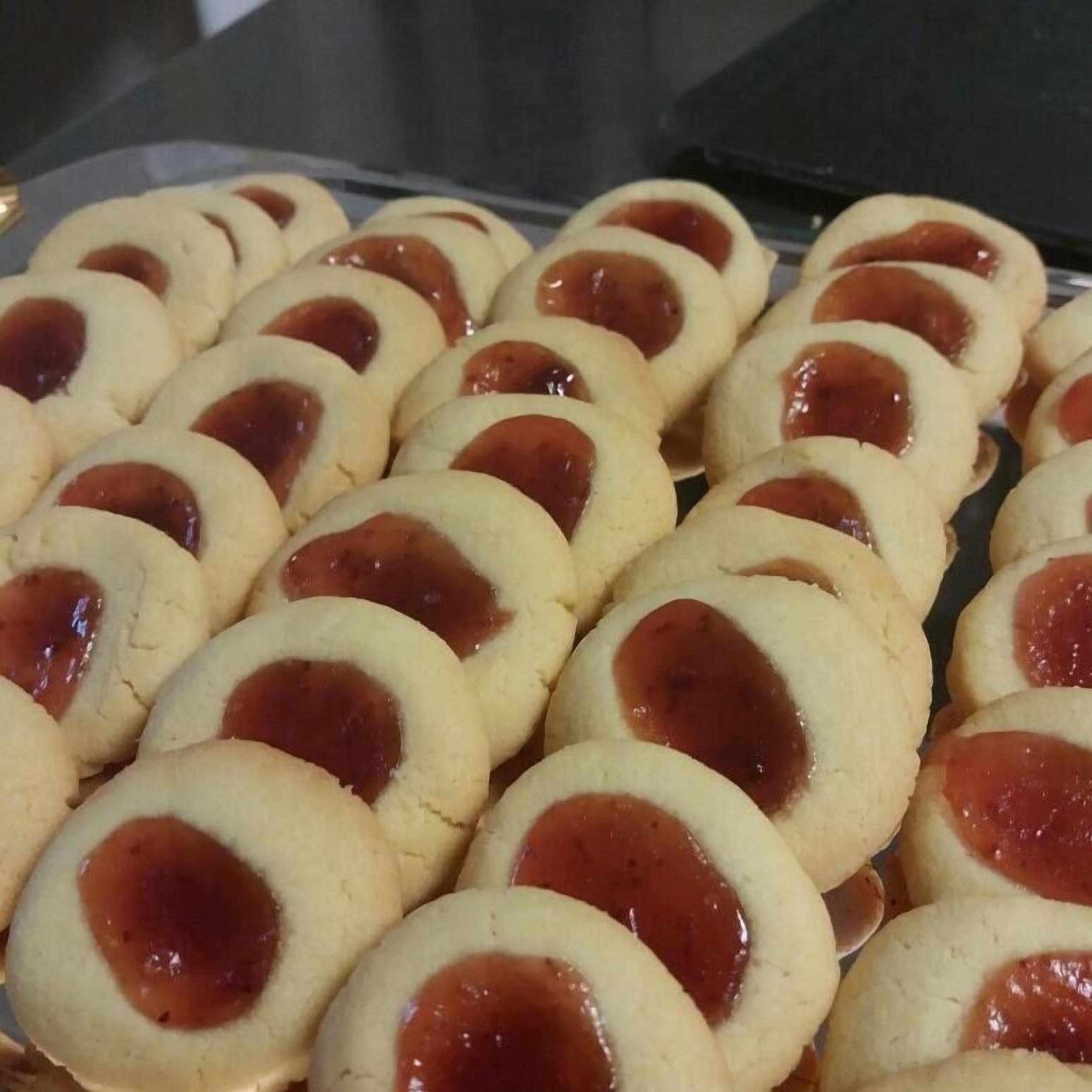A tray of round cookies with a red filling.