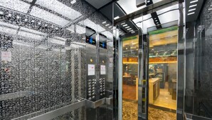 An elevator with metallic walls and floor, equipped with control panels and emergency instructions.