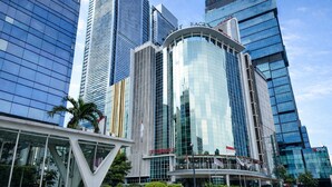 A modern building with a curved glass facade, surrounded by other high-rise structures.