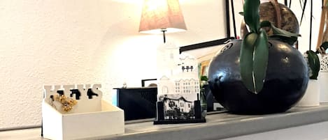 A reception desk with a clock, a lamp, and a decorative vase.
