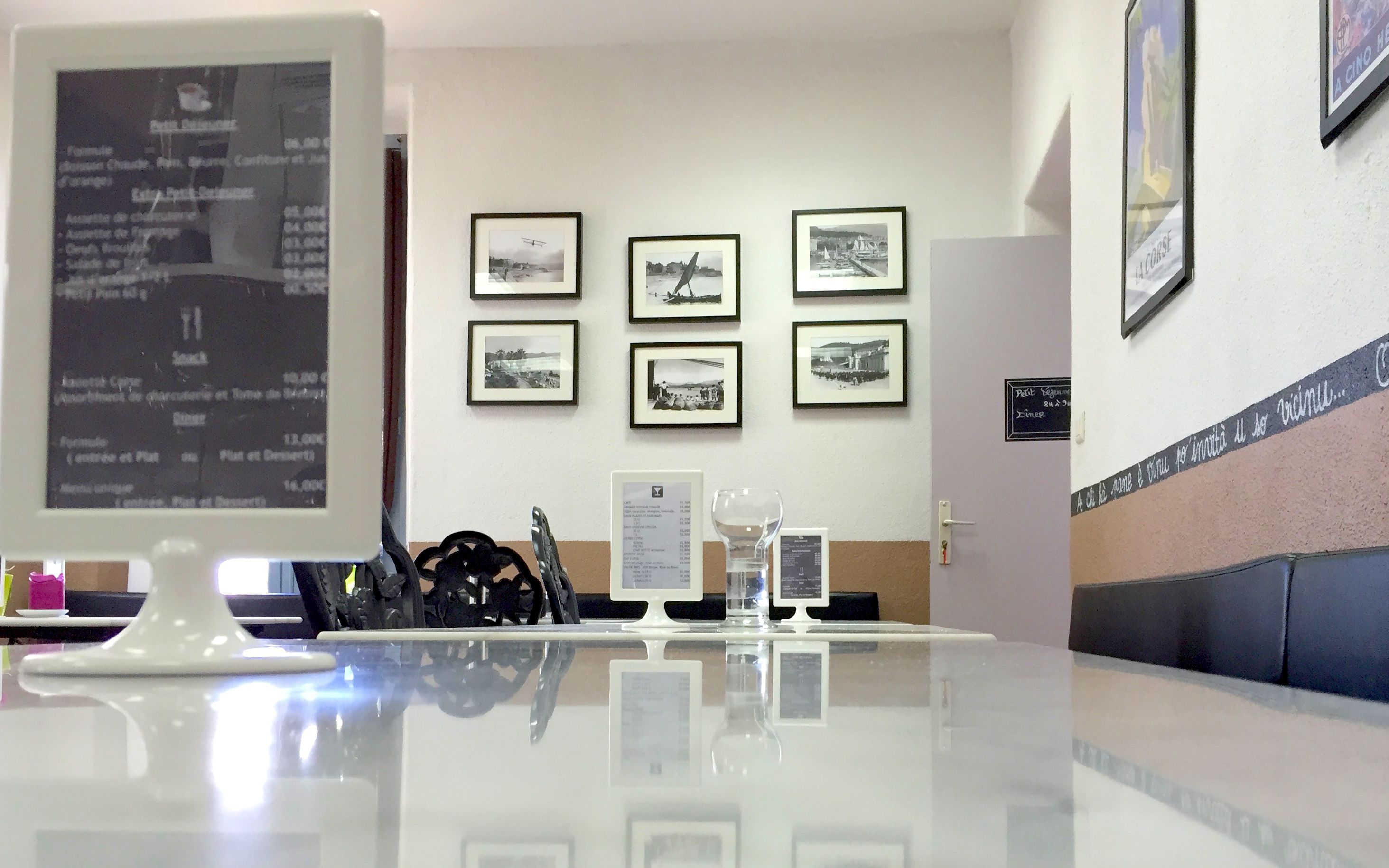 A reception area with a reception desk, framed photographs on the wall, and a seating area with a couch.