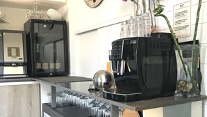 Una cocina moderna con cafetera, un reloj y un cartel de bienvenida.