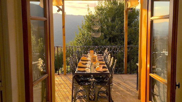 Un patio abierto con una mesa de comedor para seis personas, con vistas a un paisaje montañoso.