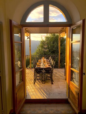 Un patio abierto con una mesa de comedor para seis personas, con vistas a un paisaje montañoso.