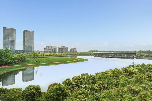 A serene lakeside view with modern buildings, a walking path, and lush greenery. - Holiday Inn Nanjing Qinhuai South Suites by IHG (Nanjing)