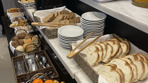 Ein reichhaltiges Buffet mit verschiedenen Speisen, darunter Brot, Gebäck, Früchte und Beilagen.