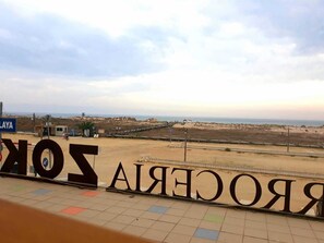 A beach view with a sign reading "SONORA" and a parking sign.