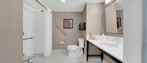A modern bathroom with a shower, toilet, and vanity.