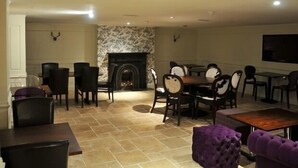 A spacious living room with a fireplace, dining area, and seating arrangements. - The Royal George Hotel (Birmingham)