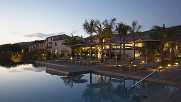 Alberca al aire libre, sombrillas en la alberca y camastros