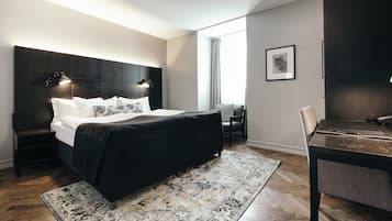 A modern bedroom with a large bed, a desk, and a chair.