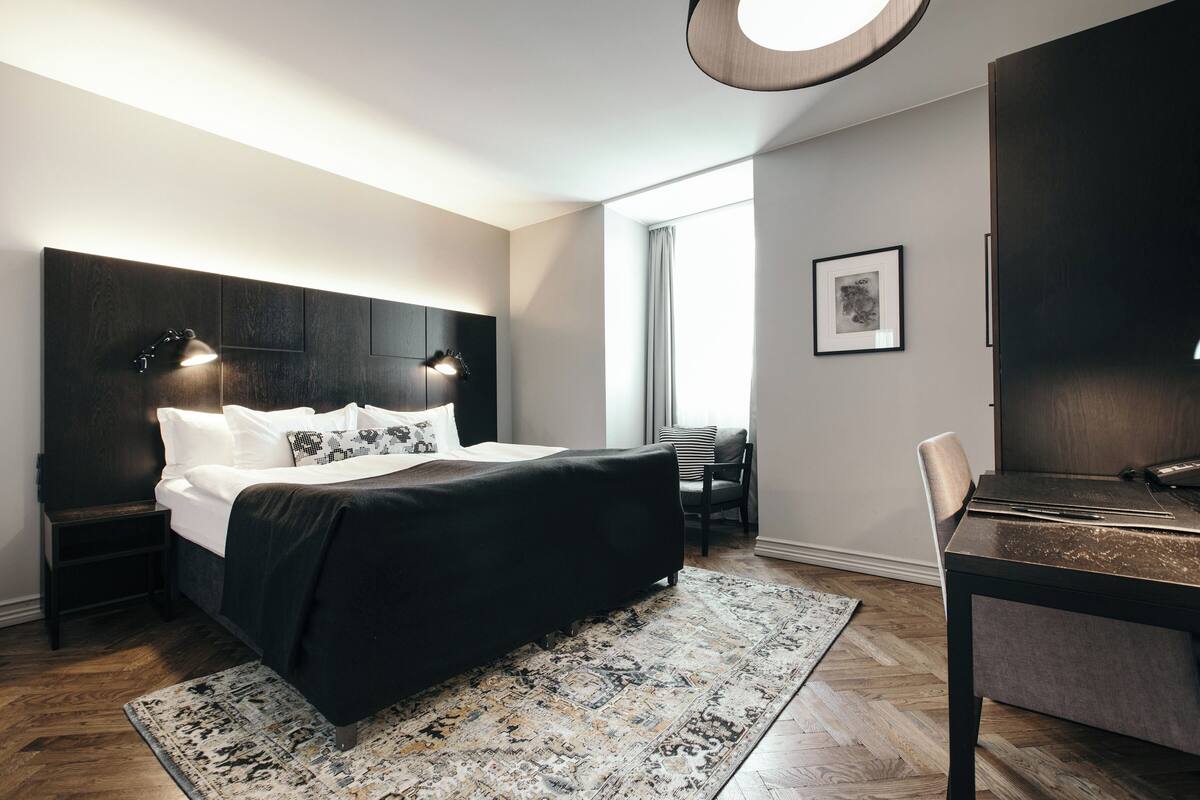 Ein modernes Schlafzimmer mit einem großen Bett, einem Schreibtisch und einem Stuhl.