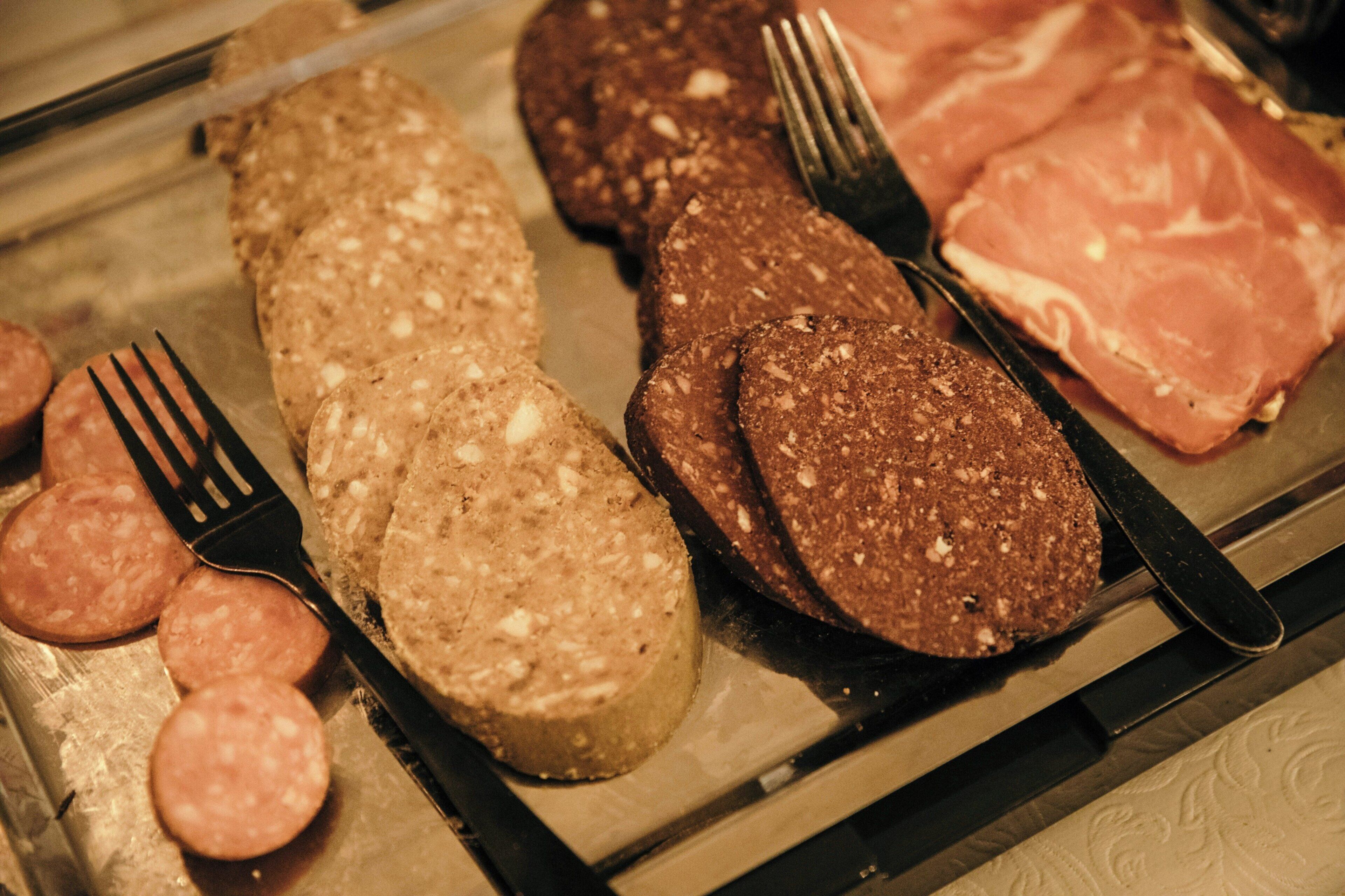Una variedad de carnes y embutidos en una bandeja.