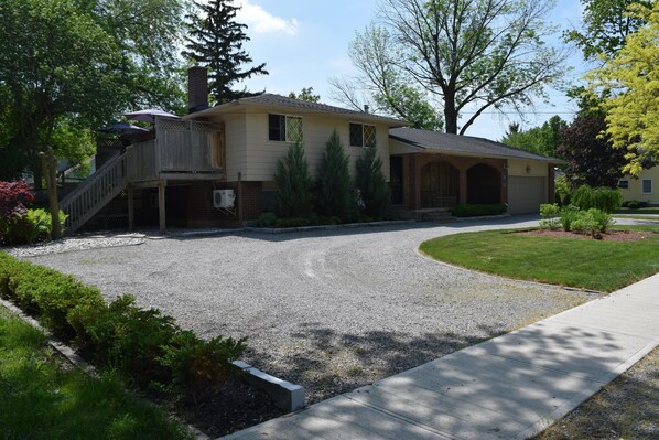 A two-story house with a covered porch, a driveway, and a well-maintained lawn.