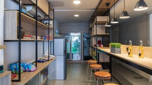 Eine moderne Küche mit Holzböden, einem Kühlschrank und Barhocker.