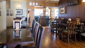 A restaurant with wooden furniture, a bar area, and a counter with a menu. - The Albert (Scarborough)