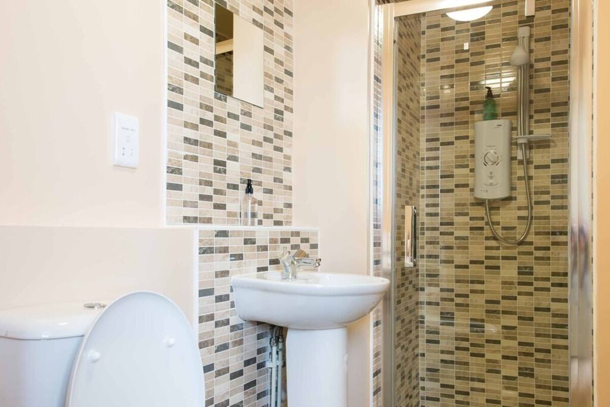 Un baño con inodoro, lavamanos y zona de ducha.