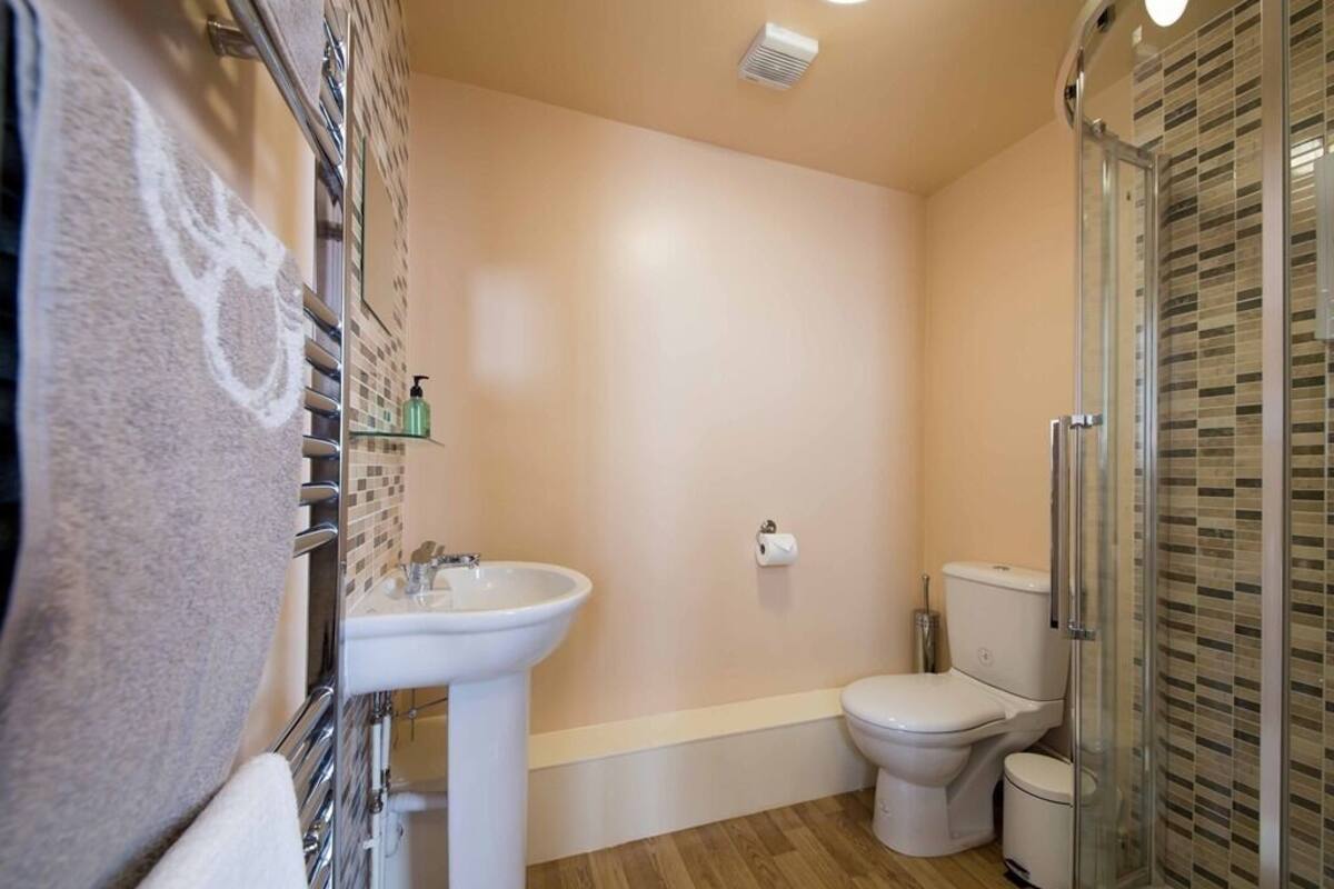 Un baño con lavamanos, inodoro y cabina de ducha de vidrio.