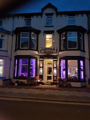 The exterior of the Mayfair Hotel with illuminated bay windows and a traditional facade. - Mayfair Hotel (Blackpool)