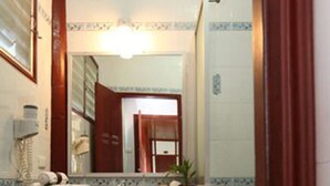 Un baño con lavamanos, espejo y ducha.