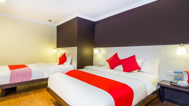 A hotel room with two beds, a wooden floor, and modern decor. - OYO 431 Hotel De Grand Orchard (Kuala Lumpur)
